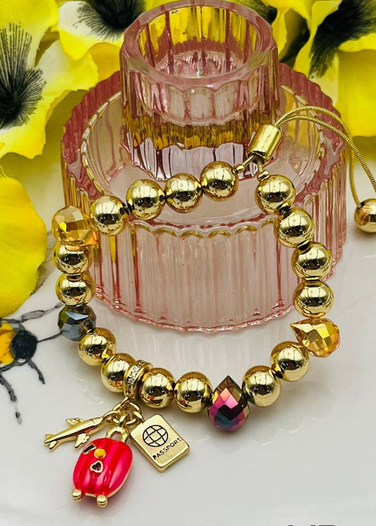 Pulsera con charm de avión y maleta además piedras en cristal