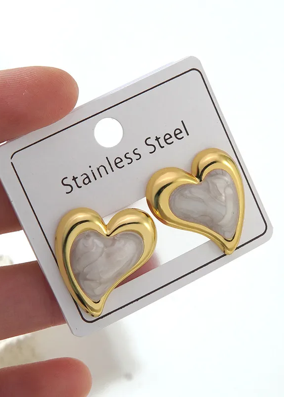 Arete de estilo de corazón dorado con fondo blanco
